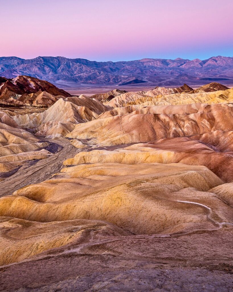  A stunning sunset over the vast salt flats of Badwater Basin in Death Valley, the lowest point in North America. The dramatic mountain range adds contrast to the serene, otherworldly landscape.