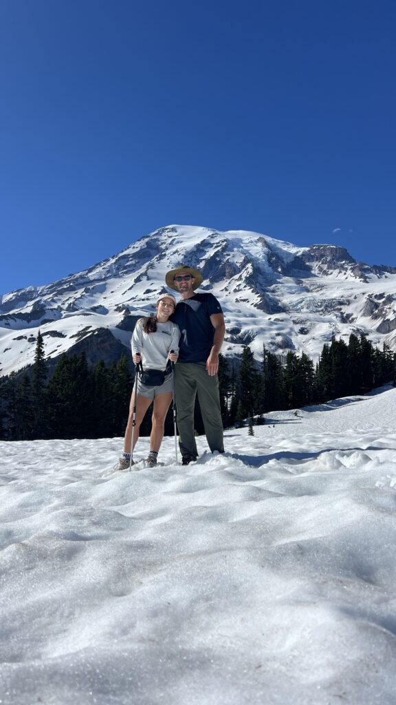 Couple hiking through a scenic trail in Mount Rainier National Park, showcasing the importance of a well-prepared National Park packing list for an adventurous and safe trip.