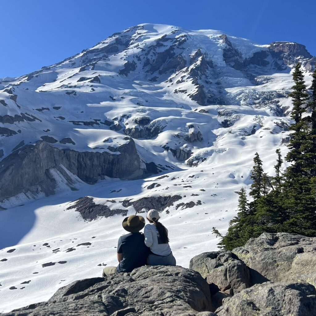 Couple enjoying the breathtaking view of Mount Rainier, the highest point in the Cascade Range and a top peak travel destination for 2025.