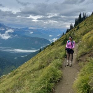 Hiker on the Highline Trail at Glacier National Park, exploring the American West and avoiding crowds at National Parks with breathtaking mountain views