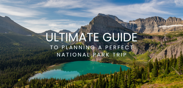 A breathtaking view of a national park featuring towering mountains, lush forests, and a serene river under a clear blue sky, illustrating the beauty and adventure opportunities to consider when Planning a National Park Trip.
