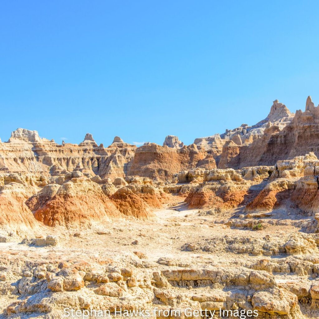 Wide-angle view of the stunning Badlands landscape in South Dakota, featuring layered rock formations and vast prairie.